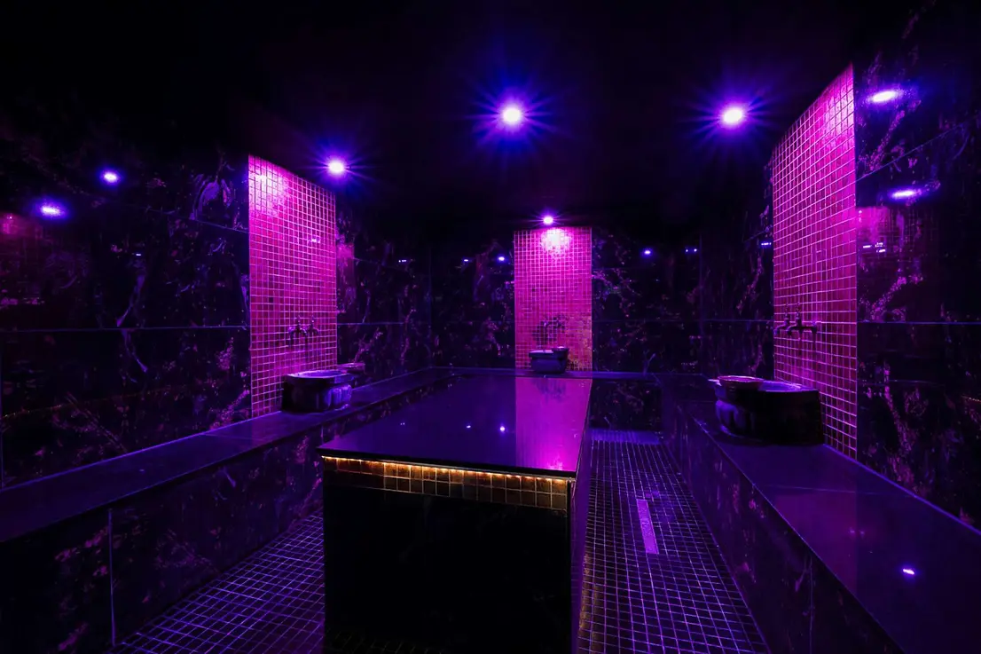 Hamam mit dunklem Marmor, Goldmosaik und farbiger Lichtinszenierung